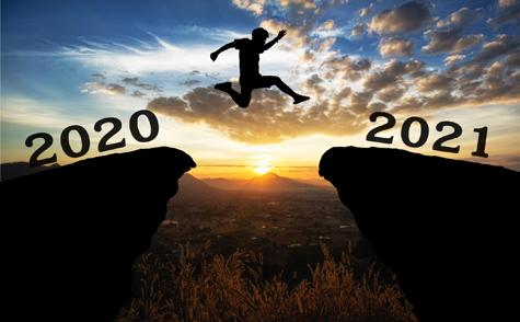 A Young Man Jump Between 2020 And 2021 Years Over The Sun And Through On The Gap Of Hill Silhouette Evening Colorful Sky.