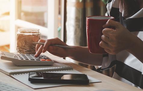 Woman Using Calculator Calculating Monthly Home Expenses, Taxes, Bank Account Balance And Credit Card Bills Payment, Concept Saving Money.